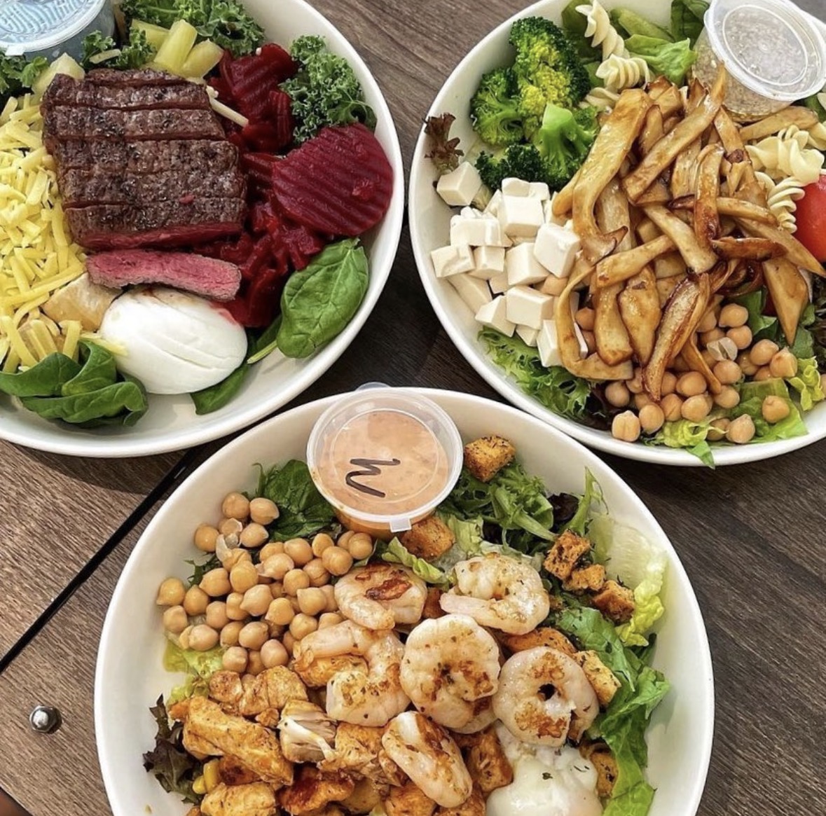 Three salad bowls from The Lawn shared on Instagram